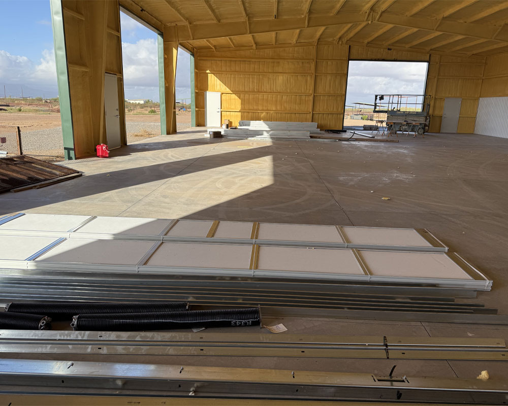 Interior of a garage door installation space featuring stacked panels, tracks, and tools, emphasizing AZ Garage Door Pros LLC's commitment to quality service and installations.