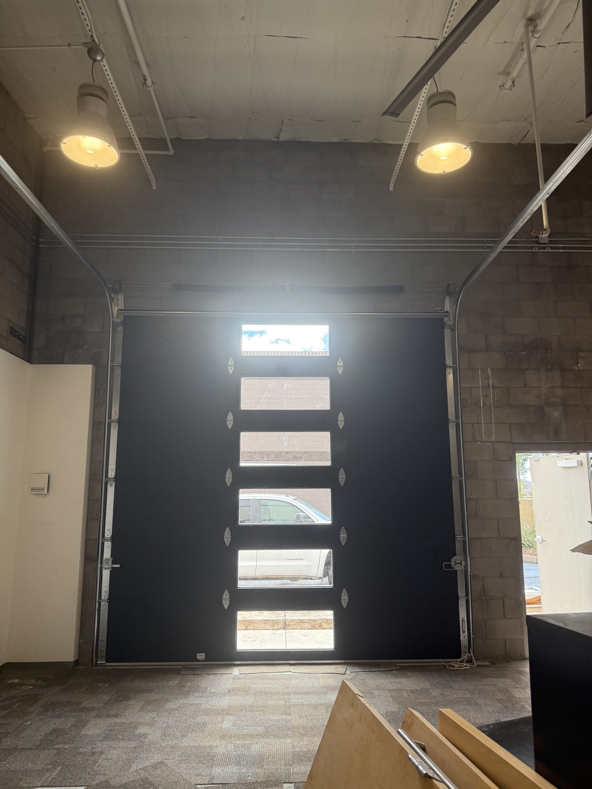 Garage door with windows partially open, showcasing interior space and natural light, emphasizing AZ Garage Door Pros LLC's installation capabilities and service environment.